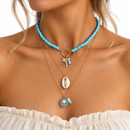 Goudkleurige gelaagde ketting met blauwe kralen, een schelp, een zeester en pareldetails rond de hals.