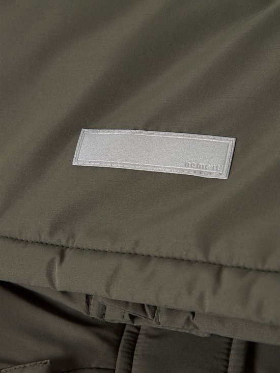 Close-up van een olijfgroene jas met een reflecterend label waarop 'name it' staat.