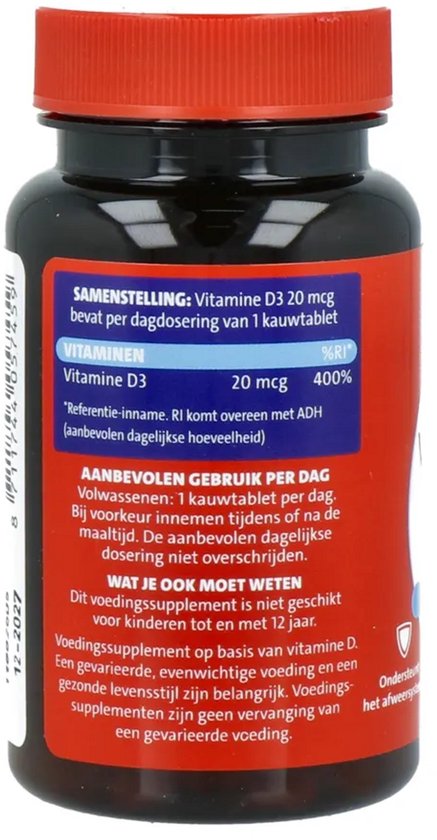 Achterkant van Dagravit Vitamine D3 potje met doseringsadvies en ingrediëntenlijst op een rode achtergrond.