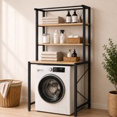 Zwart metalen frame wasmachine rek met houten planken, gevuld met handdoeken, zeepjes en mandjes. Wasmachine met witte deur zichtbaar.
