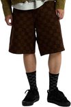 Model draagt zwarte Vans skate-sneakers met geblokte sokken en bruine short.