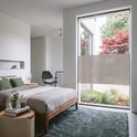 Moderne slaapkamer met een groot raam afgeplakt met een raamfolie met textielstructuur.