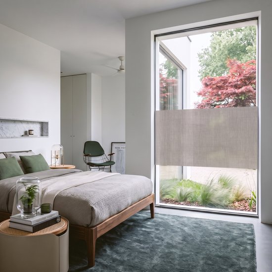 Moderne slaapkamer met een groot raam afgeplakt met een raamfolie met textielstructuur.