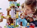Kind speelt met LEGO DUPLO 3in1 Boomhut, met kleine figuurtjes en accessoires.
