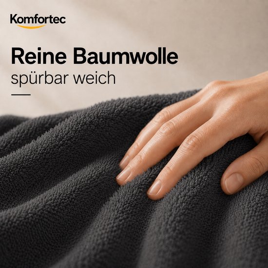 Hand met streling over een zachte, antracietkleurige katoenen handdoek. "Reine Baumwolle spürbar weich".