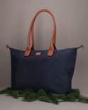Donkerblauwe Charm London schoudertas met bruine leren hengsels en een klein Charm London logo.