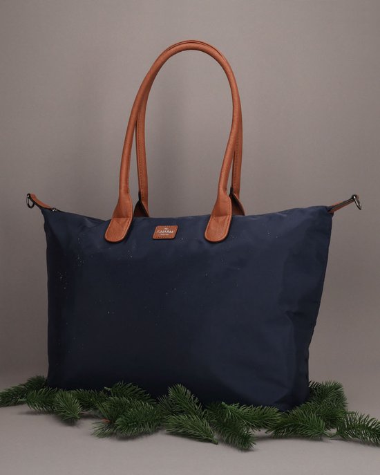 Donkerblauwe Charm London schoudertas met bruine leren hengsels en een klein Charm London logo.