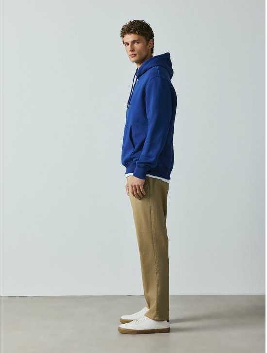 Man met zandkleurige chino en blauwe hoodie
