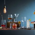 Verschillende cocktailglazen met drankjes en garnering, waaronder een martiniglas met olijf, highball glas, coupe glas, en rocks glas.