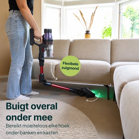 Vrouw stofzuigt onder een bank met een flexibele, rode en zwarte steelstofzuiger.