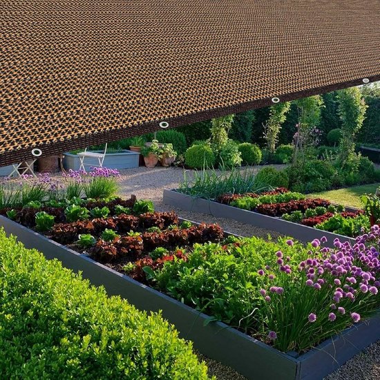 Bruin schaduwdoek boven moestuinbedden met groenten en bloemen.