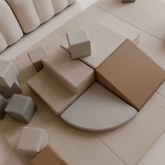 Een set van beige, crèmekleurige en grijze zachte speelblokken in verschillende vormen.