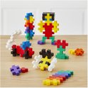 Verschillende Plus-Plus bouwwerken, waaronder een robot, auto en regenboog op een houten tafel.