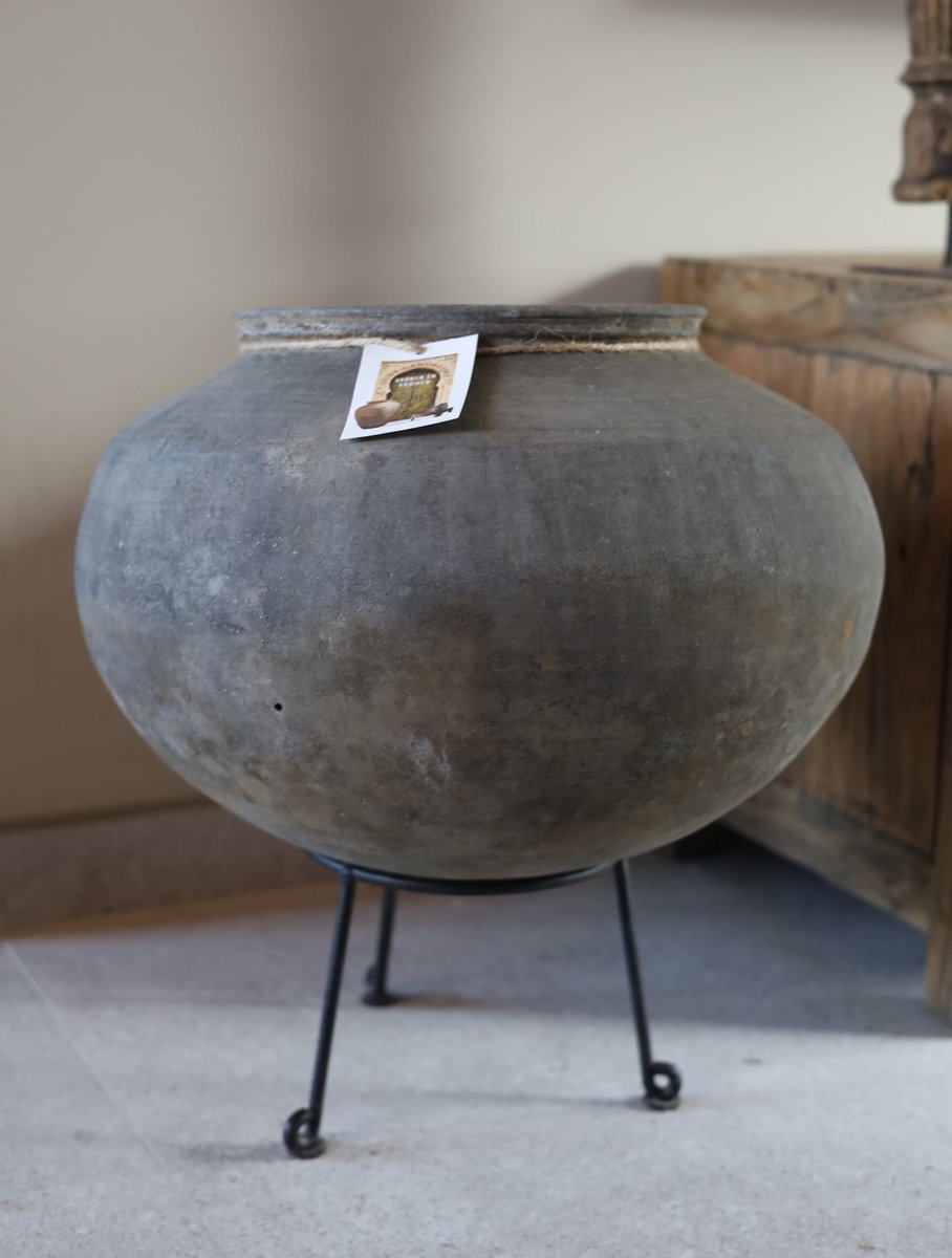 Ronde aardewerk pot op statief donker grijs landelijke kruik bloempot met zwart metalen statief