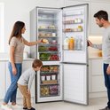 Geopend zilverkleurig Heinner koel-vriescombinatie, bekeken door een gezin.