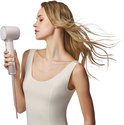Vrouw met lang, blond haar droogt haar haar met de champagnekleurige Laifen haardroger.