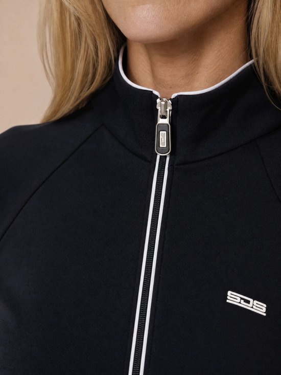 Close-up van het donkerblauwe sportvest met witte bies en rits met logo.