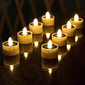 Set van 8 witte led theelichtjes met vlamloze, flikkerende 'vlammen' op een donkere tafel.
