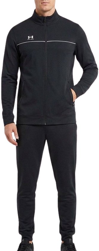Man die een zwart trainingspak draagt, bestaande uit een jack met rits en een broek, met witte accentstrepen.