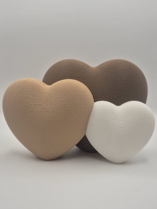 Drie decoratieve harten in de kleuren beige, bruin en wit.