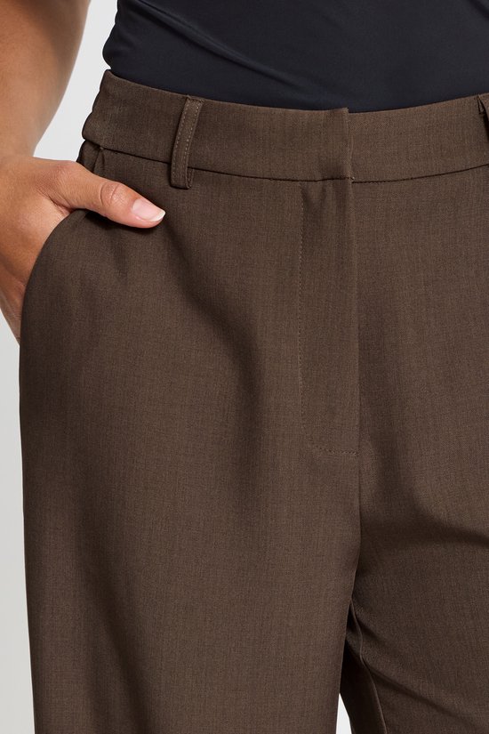 Detail van een bruine broek met steekzak, met elastische tailleband en riemlussen.