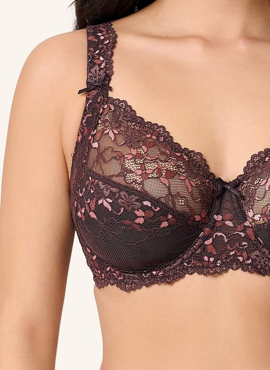 Close-up van een bruine LingaDore beugelbeha met gedetailleerd roze kant en strikjes op de bandjes.