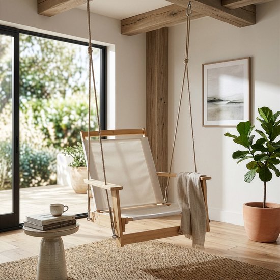 Hangstoel met houten frame en witte zitting, in een woonkamer met uitzicht op de tuin.
