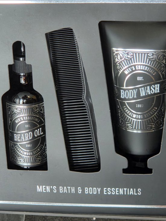 Geschenkset met zwarte body wash, baardolie met pipet en een zwarte kam in een doos, met 'Men's Bath & Body Essentials'.