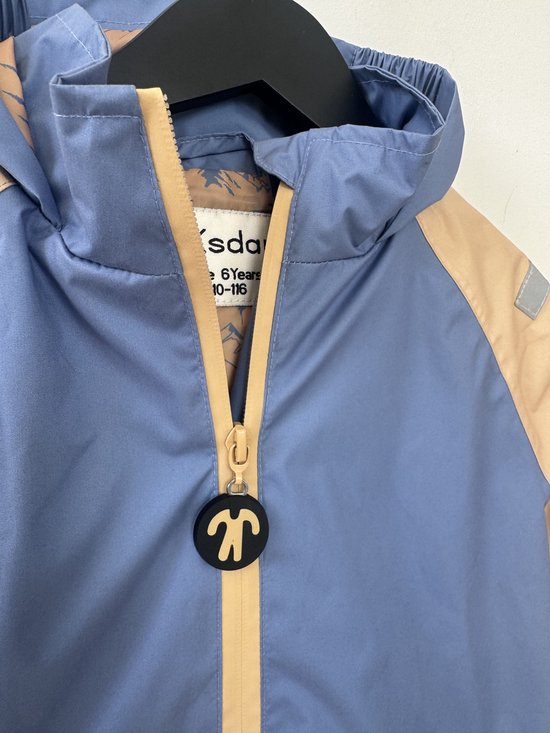 Blauwe jas met beige ritssluiting en zwarte rits hanger.