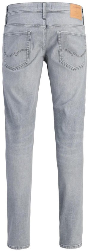Achterkant van een man in een grijze jeans met rechte pijpen en zwarte schoenen.