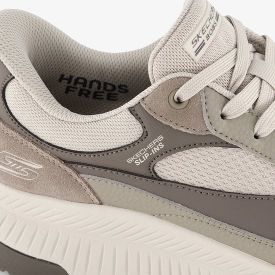 Detail van de instap van een beige sneaker met suède en mesh, "Hands Free" en "Skechers Slip-ins".