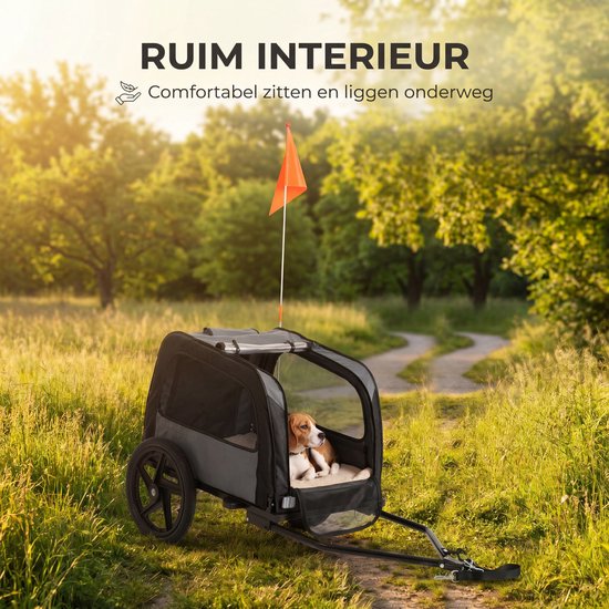 Zwarte en grijze hondenfietskar op een bospad met een beagle erin, met "RUIM INTERIEUR".