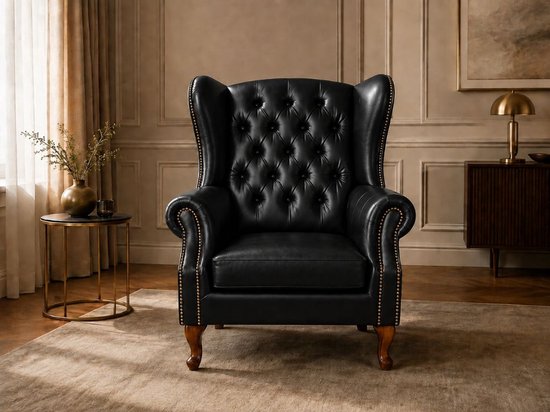 Zwarte Chesterfield fauteuil met diepe knopen op de rug en armleuningen, gouden studs, houten poten.