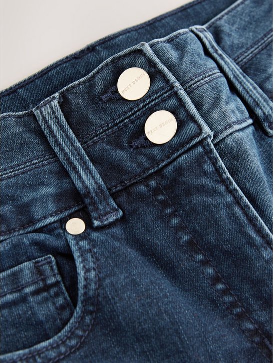 Close-up van de knoopsluiting van een donkerblauwe jeans met twee knopen en merkopdruk.