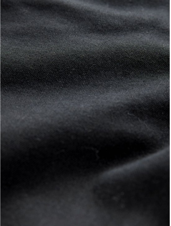Close-up van de textuur en de diepzwarte kleur van de denim stof.