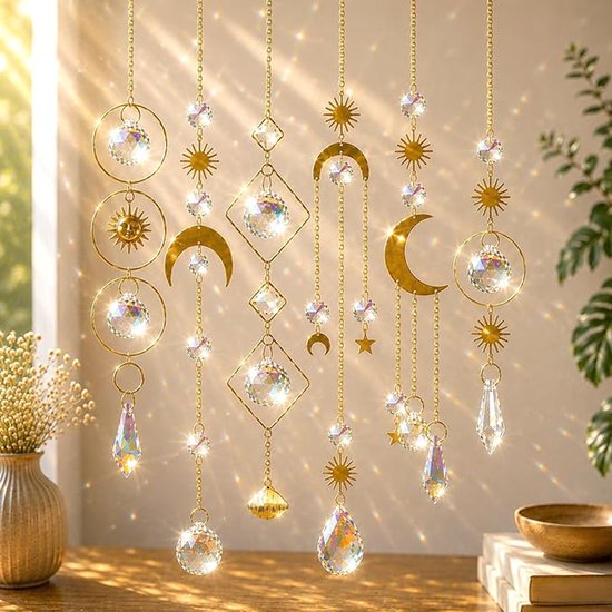 Gouden hangers met kristallen, manen, zonnen en sterren, die stralend licht weerkaatsen.