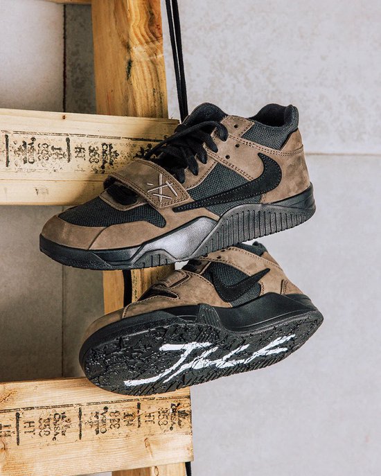 Twee Jordan Jumpman Jack TR schoenen. Een paar hangt, de andere ligt met witte lijnen op de zwarte zool.
