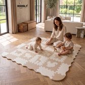 Moeder zit op een beige en witte speelmat met dierenmotieven, naast haar twee spelende kinderen.