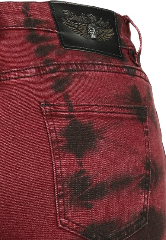 Rode jeans met zwarte batikprint en een zwart leren patch met een gevleugelde schedel erop.