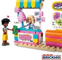 Een LEGO Friends minipop bij een snoepkraam met suikerspin en een jongen met geld.