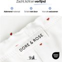 Close-up van een witte pyjamaset met rode hartjes. Het label 'DORE & ROSE' is zichtbaar.
