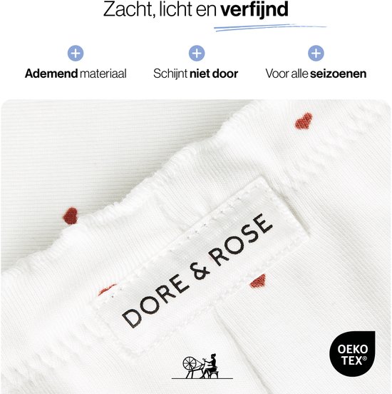 Close-up van een witte pyjamaset met rode hartjes. Het label 'DORE & ROSE' is zichtbaar.