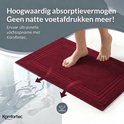 Een bordeauxrode badmat absorbeert water direct, voorkomt natte voetafdrukken op de vloer. Pijlen tonen absorptie.