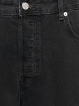 Detail van de voorkant van een zwarte jeans. Knoopsluiting, stiksels en een zak met knoop.