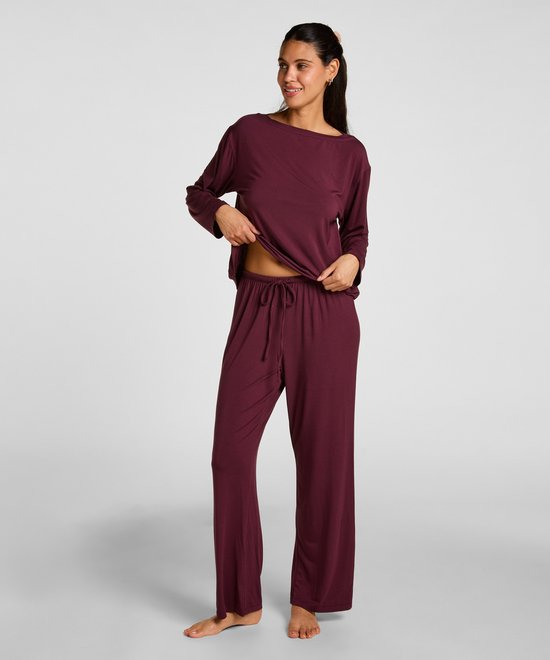 Dames, een donkerrode pyjamaset met lange mouwen en broek, model laat de pyjamabroek zien.