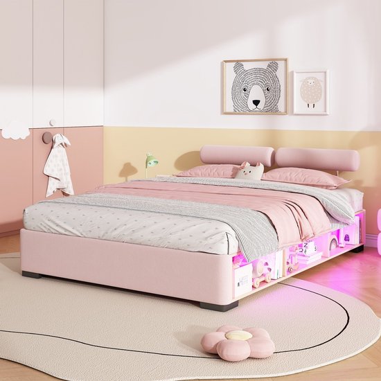 Roze kinderbed met opbergruimte en LED-verlichting, opgemaakt met roze en grijs beddengoed.