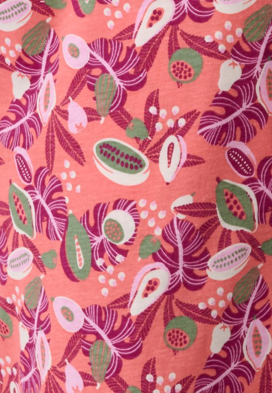 Detail van een roze pyjamabroek met een tropische print van bladeren en fruit in roze, groen en wit.