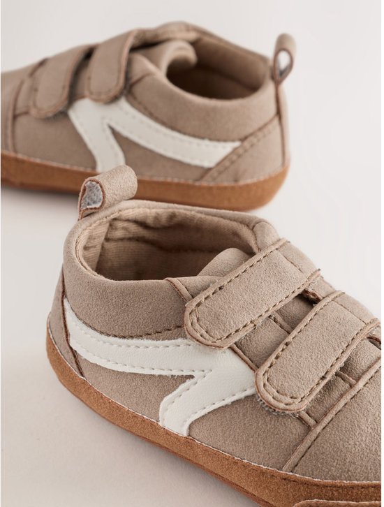 Bruine suède babysneakers met witte strepen en klittenbandsluiting.