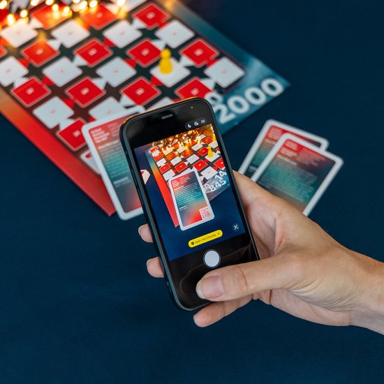 Smartphone met spelscherm van Top 2000 Muziekquiz, de vakjes zijn rood en wit met lichtjes.