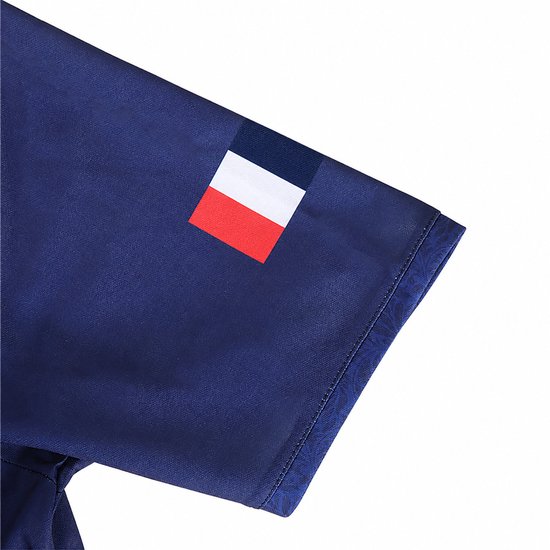 Détail d'un maillot de football bleu marine avec drapeau français sur la manche et bordure décorative.
